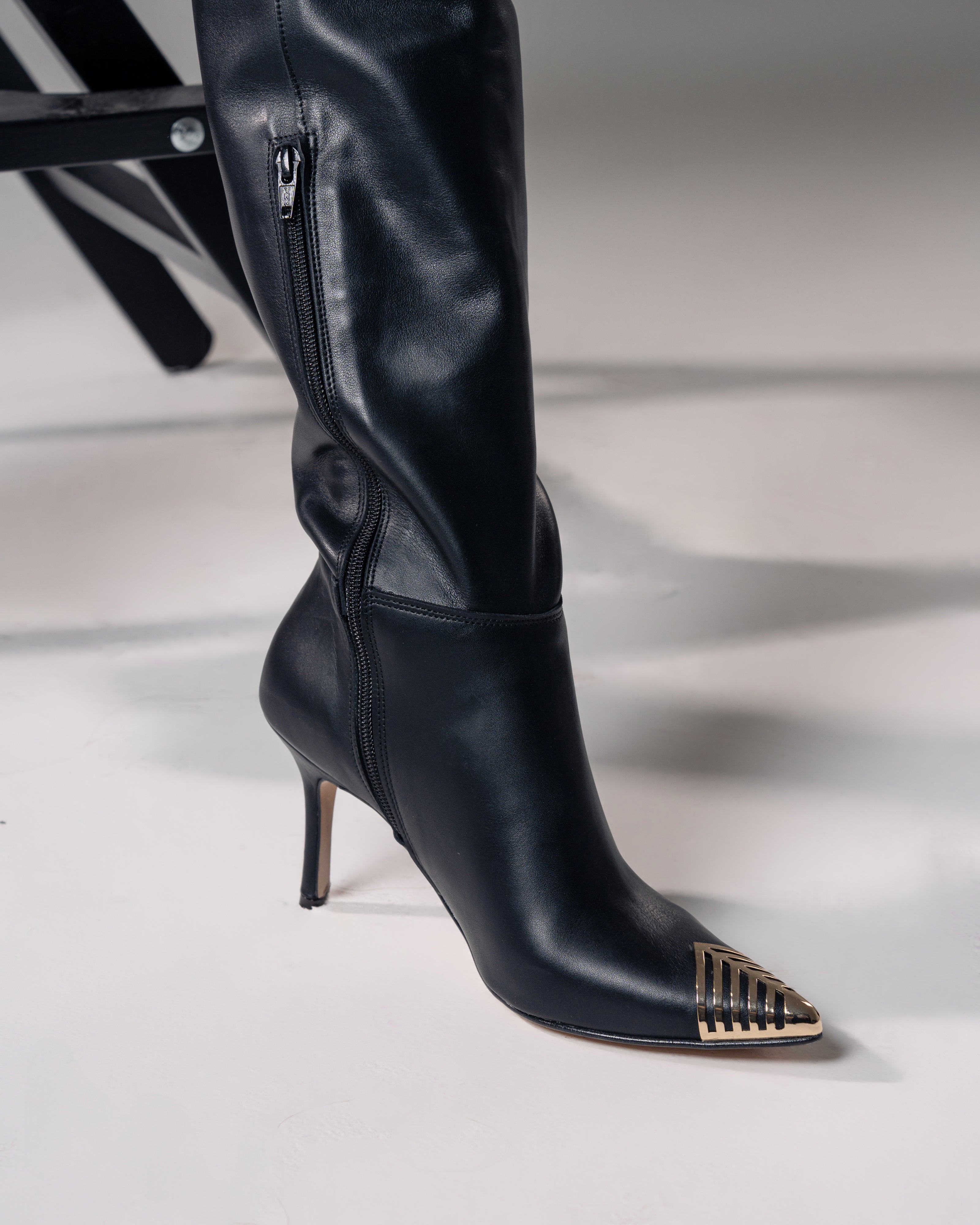 OBLIQUE - Tubular boot in genuine leather with asymmetric cut and gold plaque